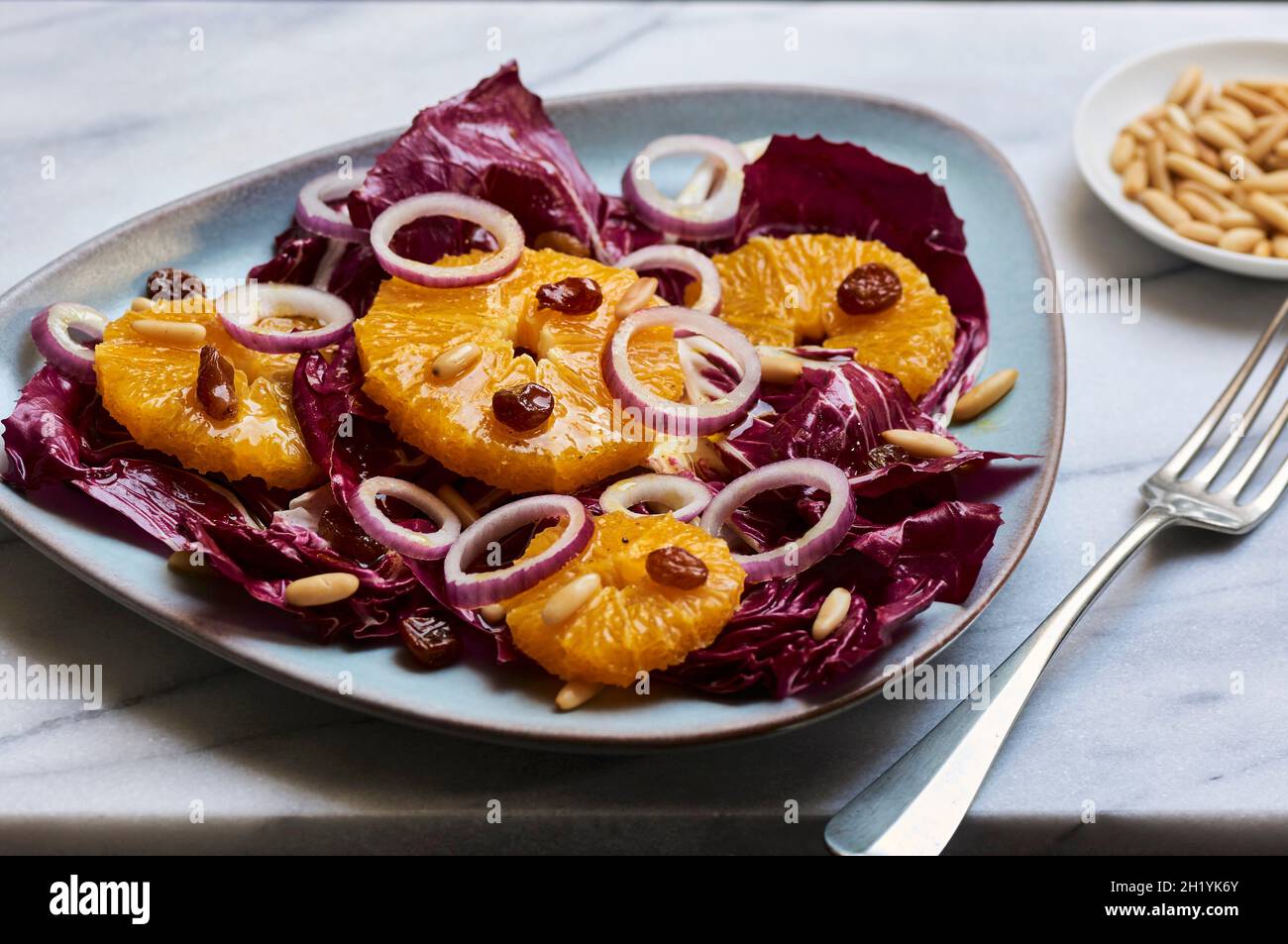 Salade radicchio hivernante avec oranges, oignons rouges, raisins secs et pignons Banque D'Images