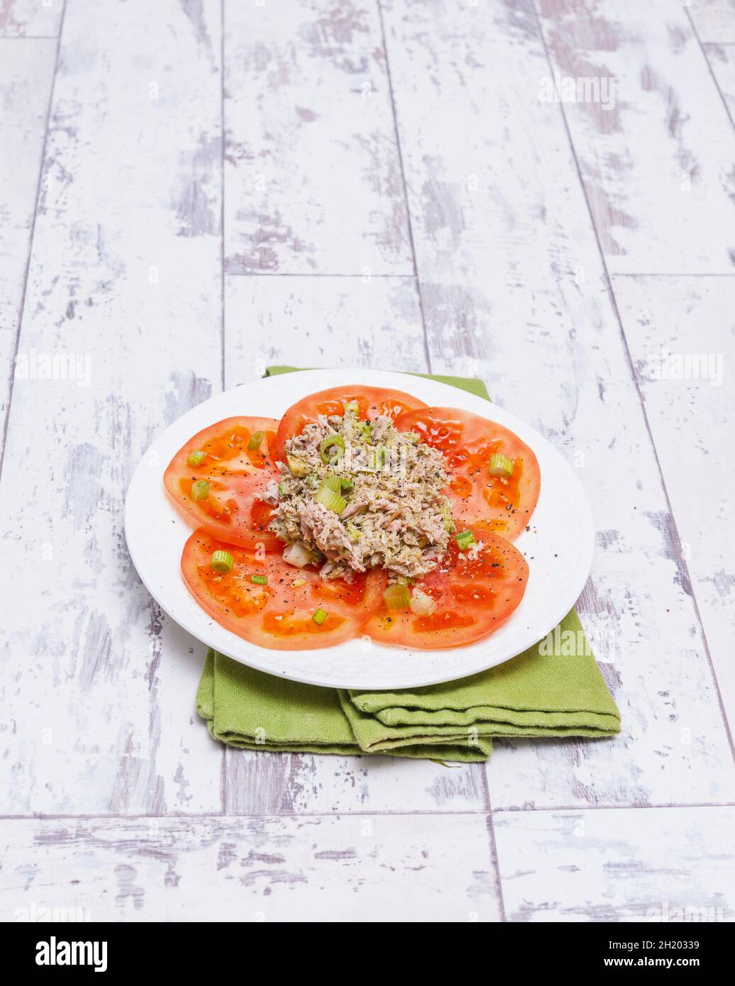 Pâte d'avocat et de thon avec oignons de printemps sur tranches de tomate Banque D'Images