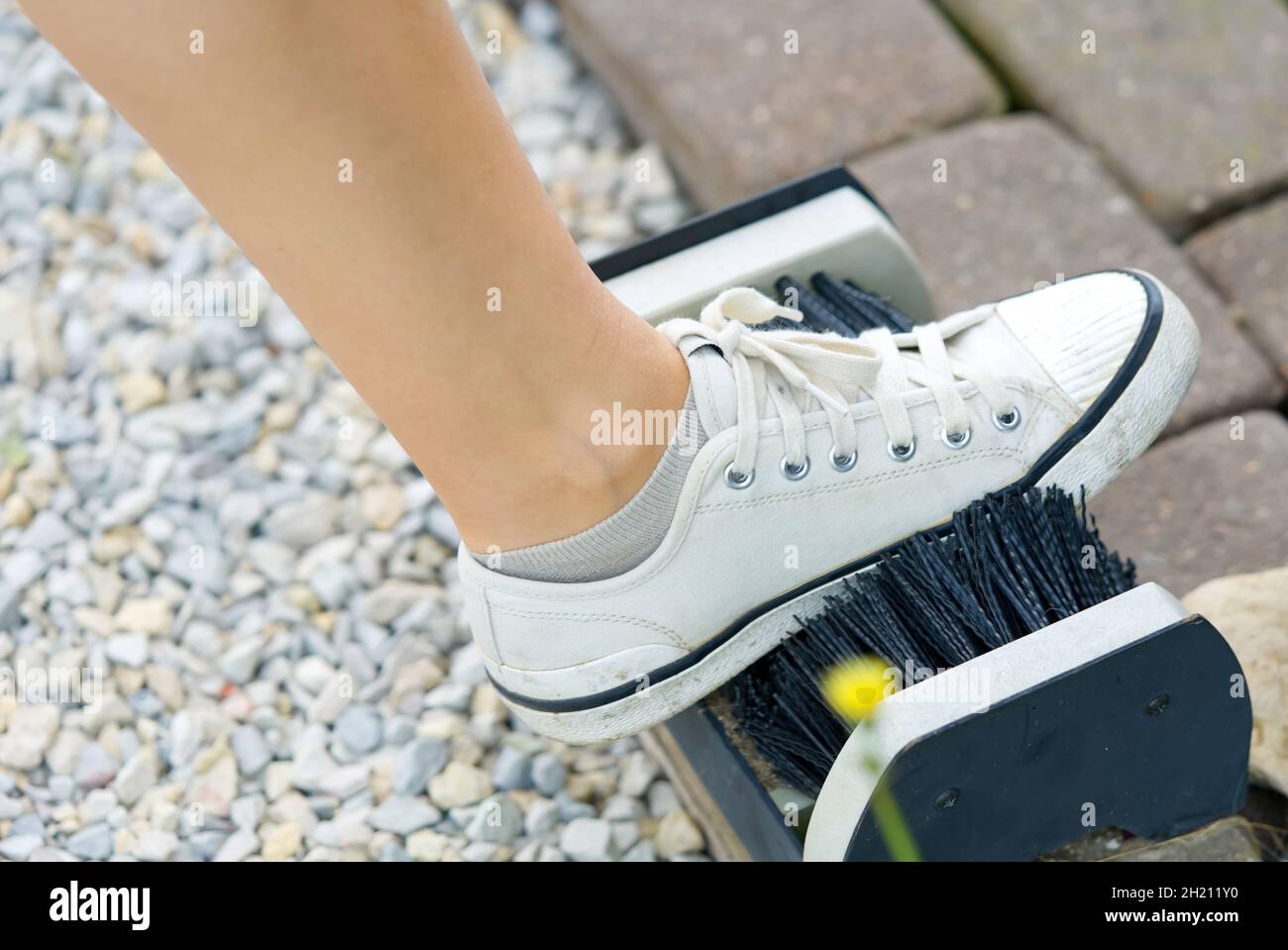 Une fille nettoie les chaussures dans la rue avec une brosse spéciale Banque D'Images