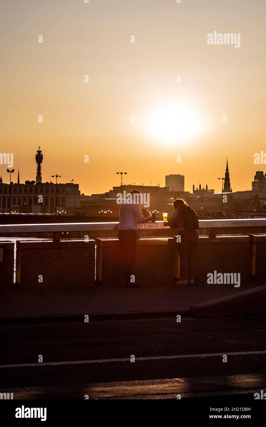 Deux personnes prenant un verre sur le London Bridge au coucher du soleil, Londres, Royaume-Uni Banque D'Images