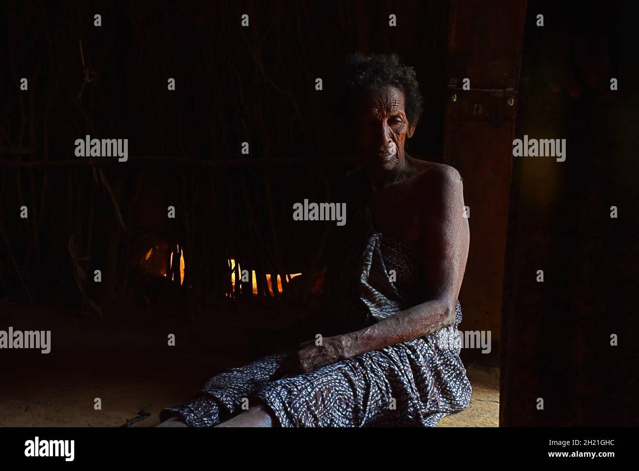 Une vieille femme mentalement malade gardée en chaîne dans un petit refuge par sa famille pour ne pas se blesser.Un village en Ouganda. Banque D'Images