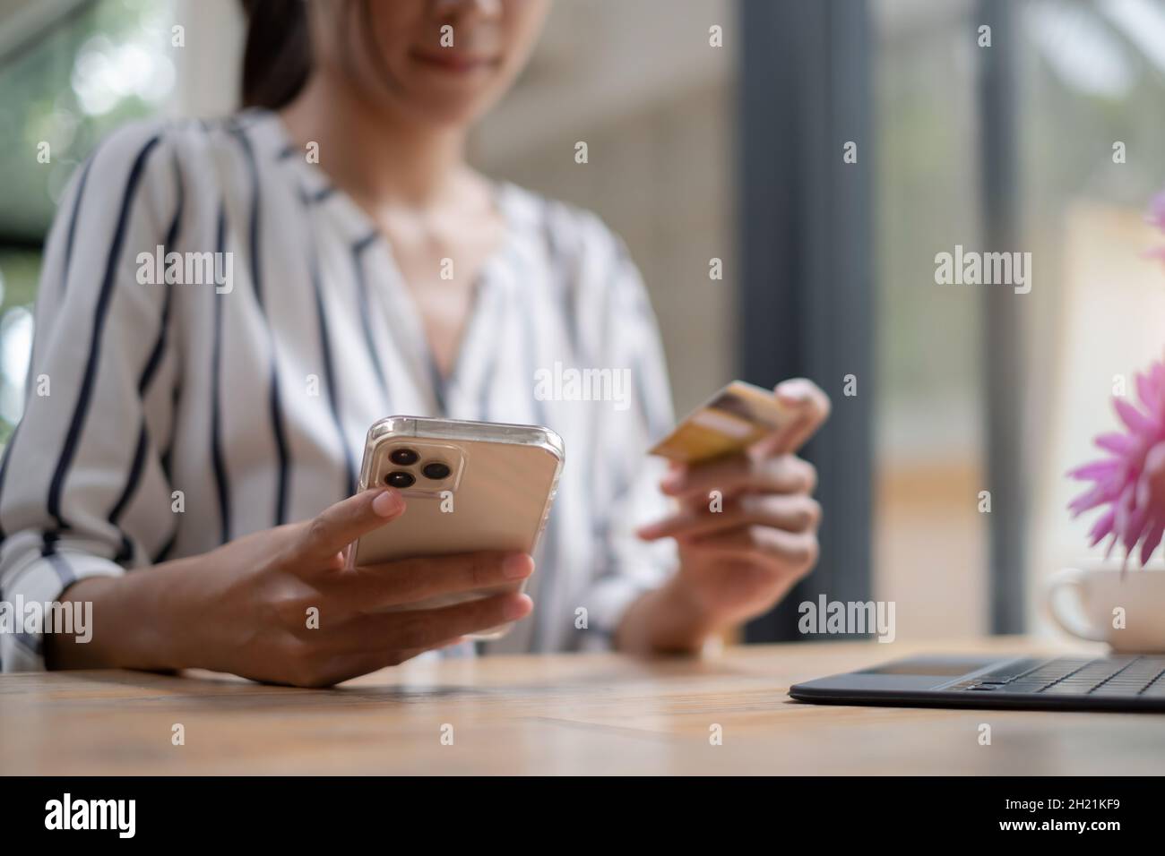 Belle femme tenant smartphone en utilisant la plate-forme d'ecommerce et de profiter avec les achats en ligne et la saisie de carte de crédit pour remplir le numéro de paiement. Banque D'Images