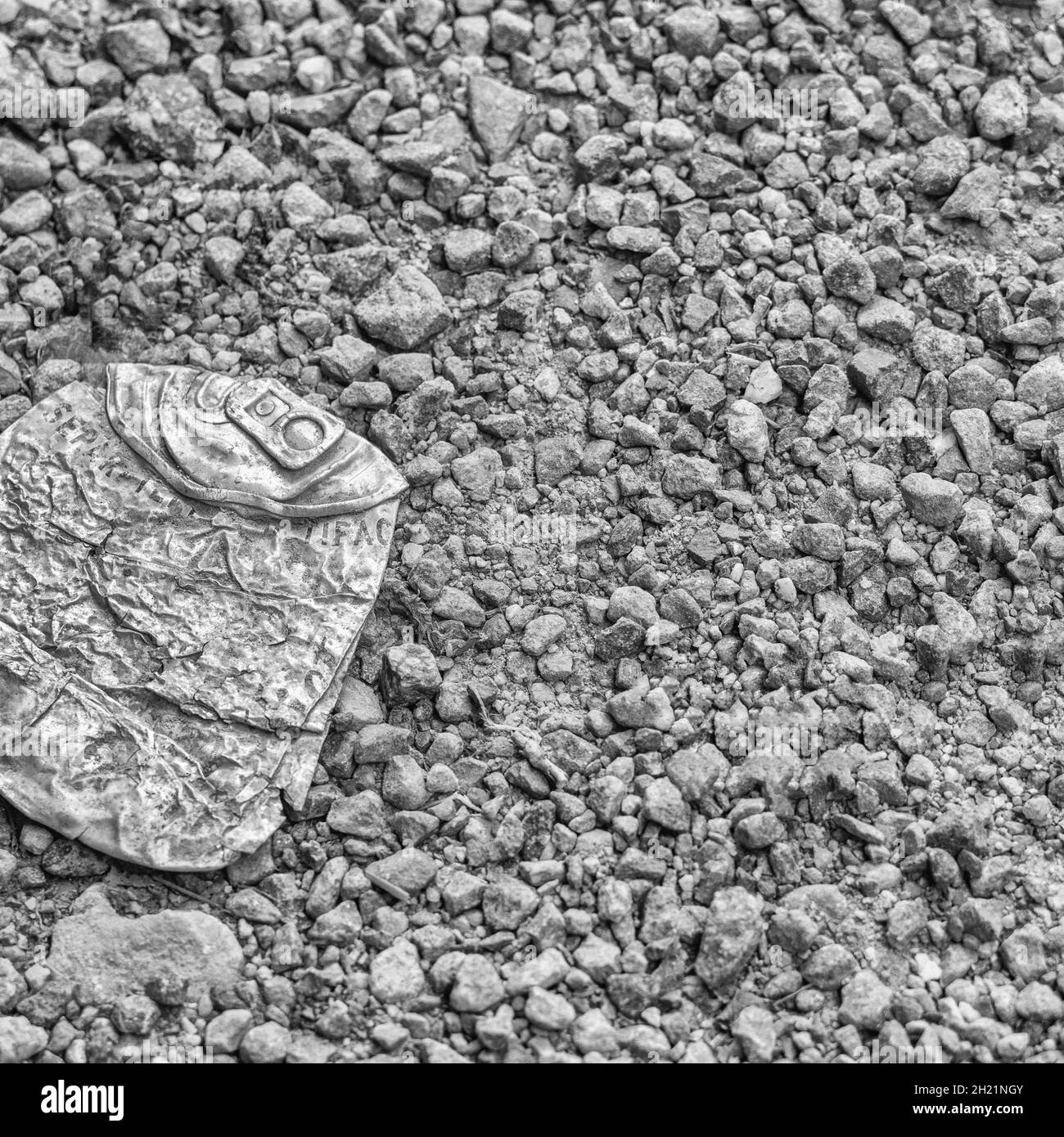 Conversion monochrome de l'anneau en métal concassé sur le gravier.Pour quelque chose écrasé, métal abstrait, métallique.La version originale est 2H21NKR. Banque D'Images