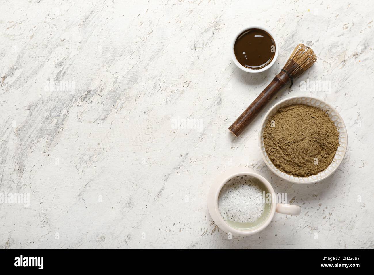 Bol avec poudre de hojicha, tasse de thé et chasen sur fond clair Banque D'Images