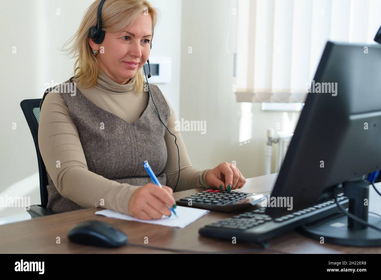 Analyse des données financières.Photo en gros plan d'une femme d'affaires qui écrit et compte sur la calculatrice au bureau.Mise au point sélective. Banque D'Images