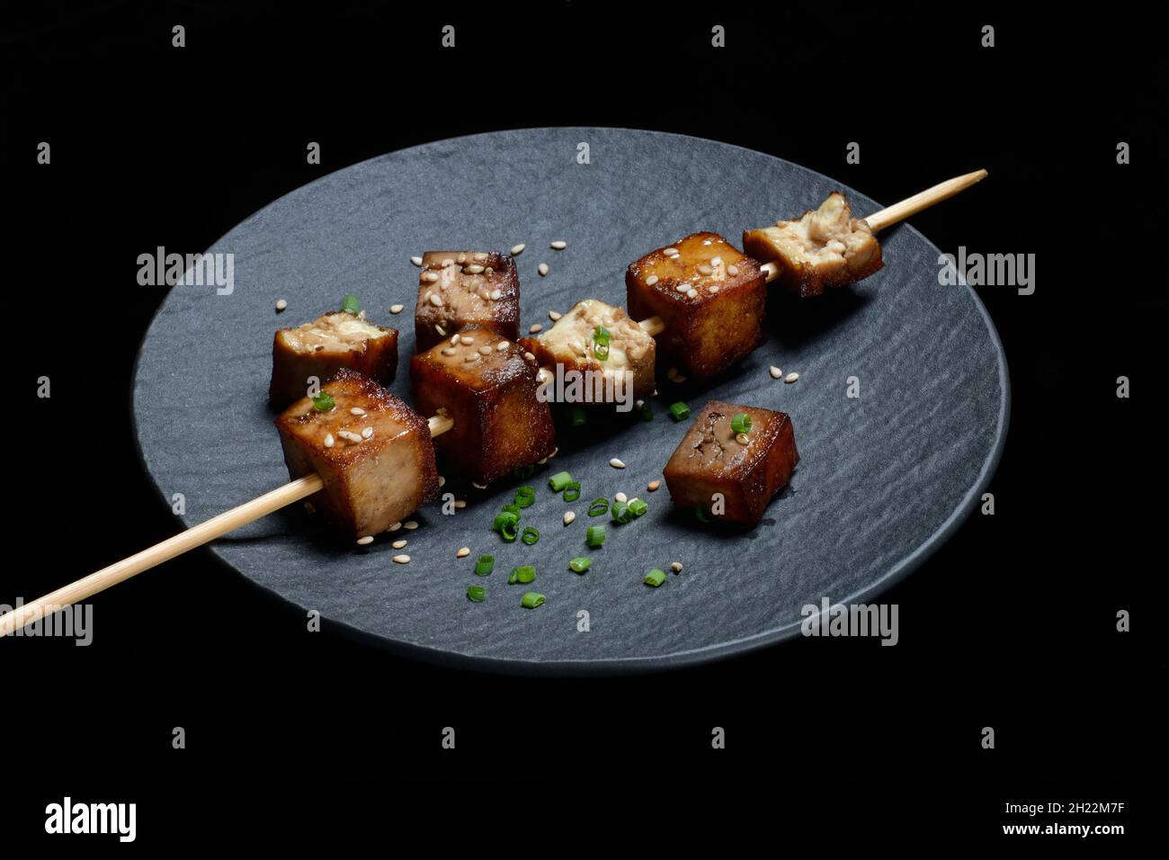 Cubes de tofu frits avec brochette en bois sur l'assiette Banque D'Images