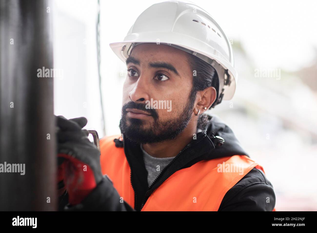 Un technicien de barbe et de casque travaille dans un atelier, Fribourg, Bade-Wurtemberg, Allemagne Banque D'Images