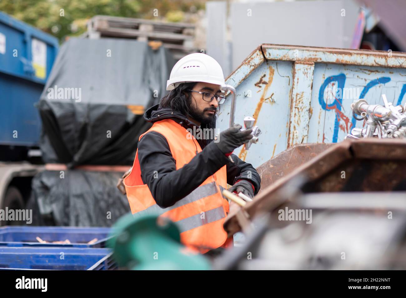 Technicien avec barbe et casque travaillant dans une cour de recyclage, Fribourg, Bade-Wurtemberg, Allemagne Banque D'Images