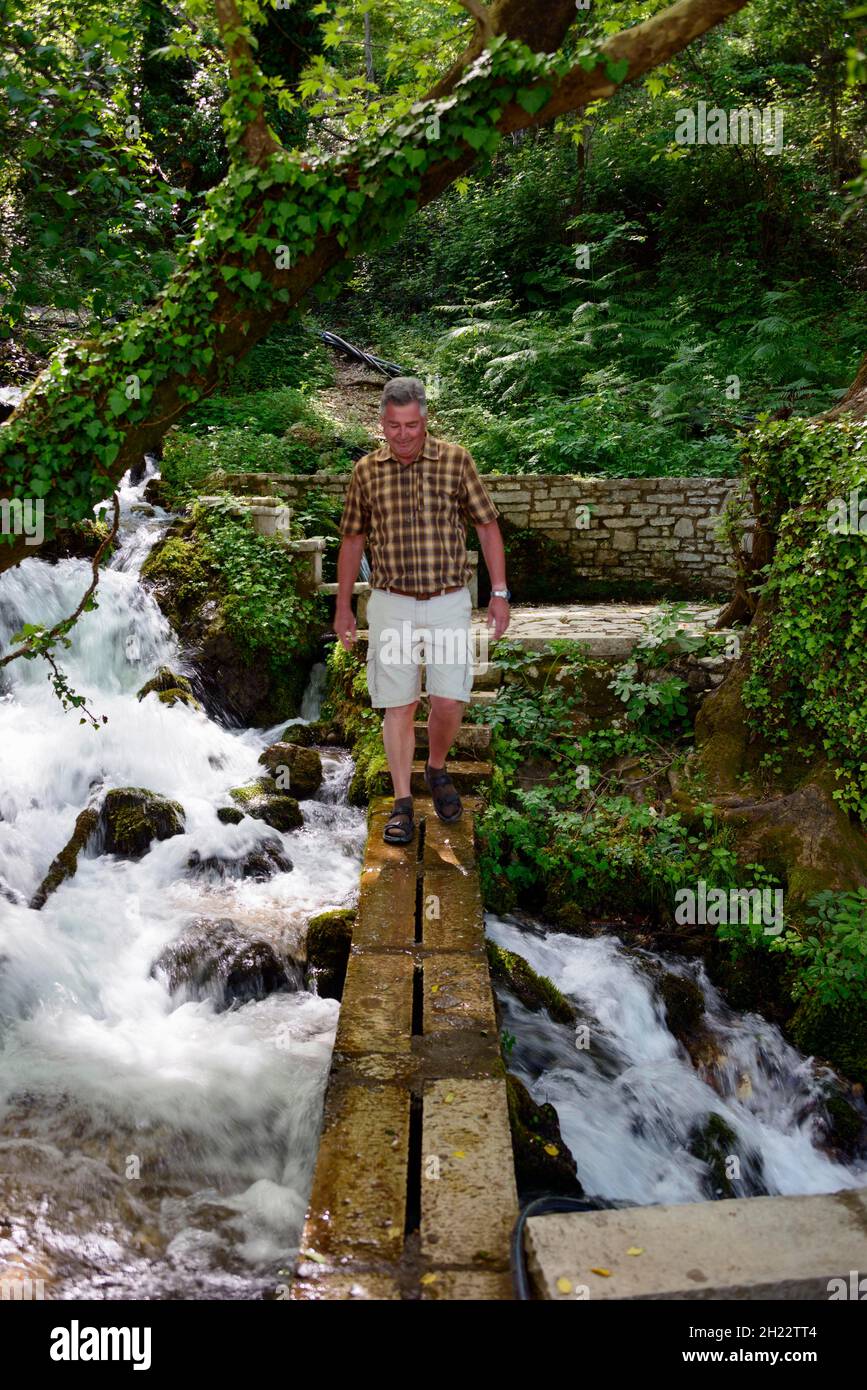 Homme sur la jetée, source, monument naturel d'eau froide, Uji i Ftothe, modèle de libération, Albanie Banque D'Images