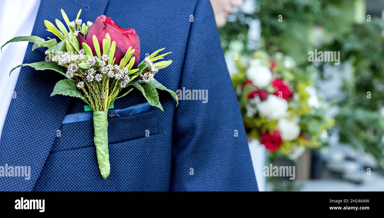 Boutonnière de mariage du marié sur un costume bleu.Fleuriste de mariage.Prêt pour la cérémonie de mariage.Arrière-plan flou.Format de bannière Banque D'Images