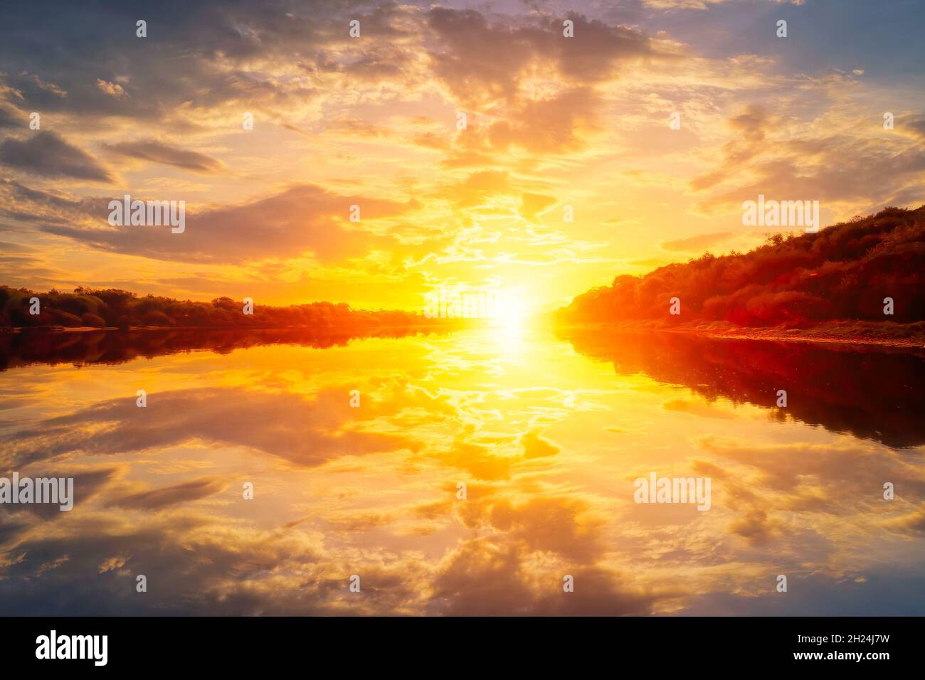 Coucher de soleil sur la rivière en soirée d'été avec des nuages et des saules.Reflet d'eau d'un ciel. Banque D'Images