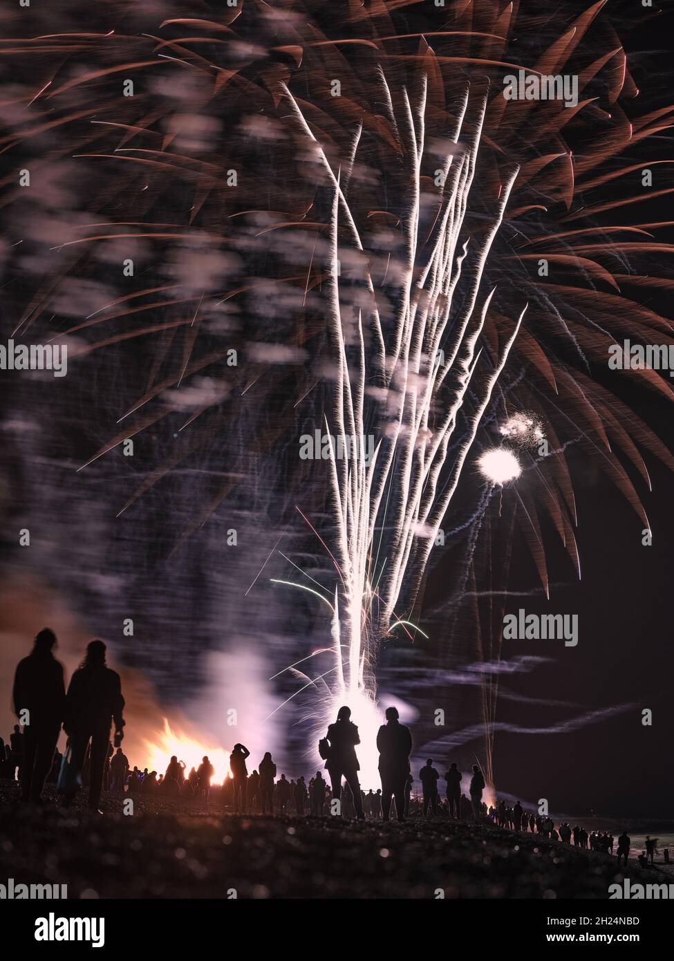 Silhouettes / figures sur la plage appréciant le feu d'artifice annuel de la Hastings Borough Bonfire Society et l'exposition de nuit de feu d'artifice 16 octobre 2021 Sussex Royaume-Uni Banque D'Images