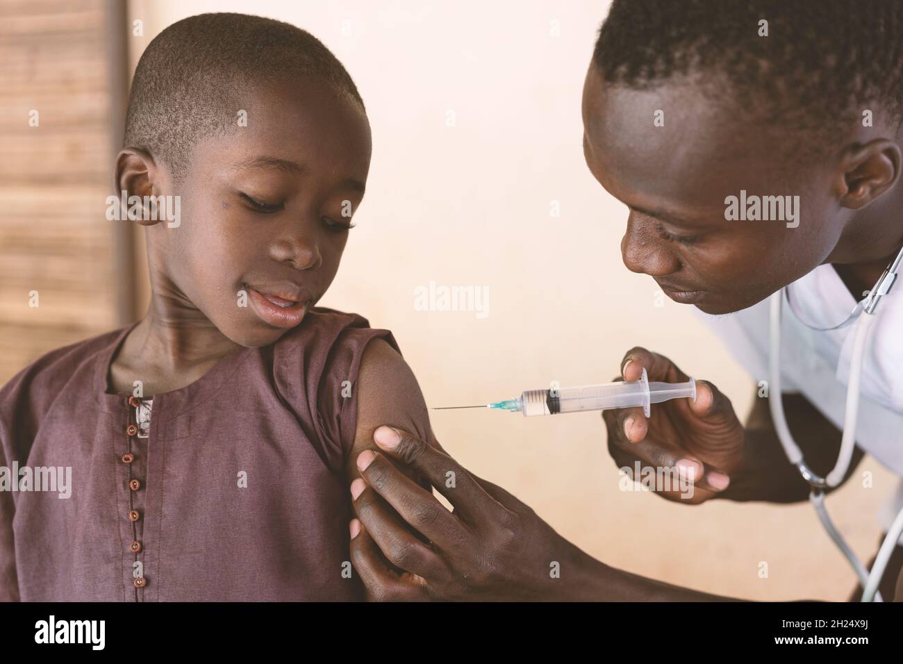 Dans cette image, un tout-petit noir reçoit son premier vaccin antipaludique dans un petit dispensaire de la communauté rurale africaine Banque D'Images