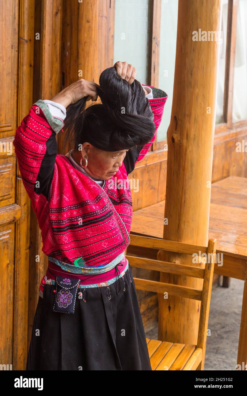 Une femme de la minorité ethnique de Red Yao fixe ses cheveux longs  traditionnels.Jinkeng, Longshen, Chine Photo Stock - Alamy