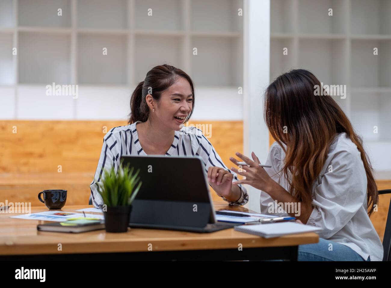 Deux femmes d'affaires se réunissent pour réfléchir au nouveau plan de stratégie d'affaires du projet et au nouveau document de données d'analyse, le concept financier et comptable Banque D'Images