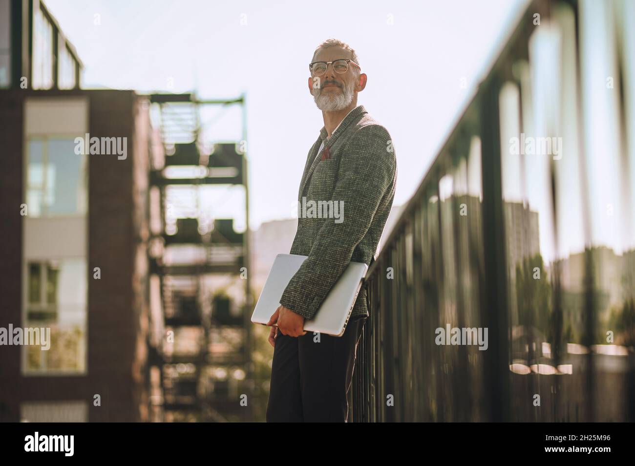 Un homme caucasien en particulier avec l'ordinateur portable regardant dans la distance Banque D'Images