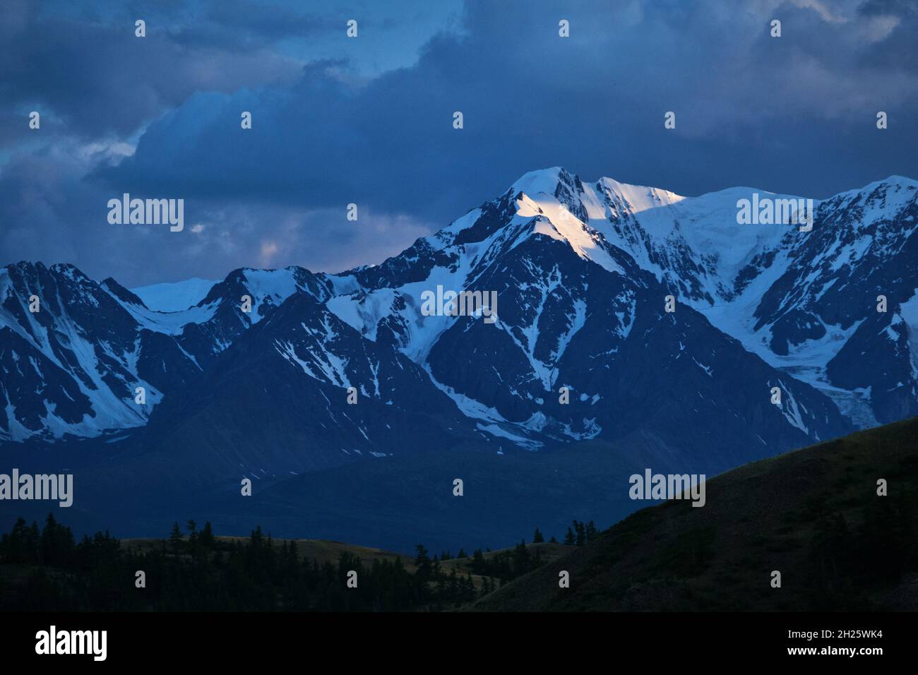 Forte lumière de coucher de soleil qui brille dans la soirée sur la montagne Aktru qui sont couvertes de neige.Région de l'Altaï, Sibérie occidentale, Russie Banque D'Images