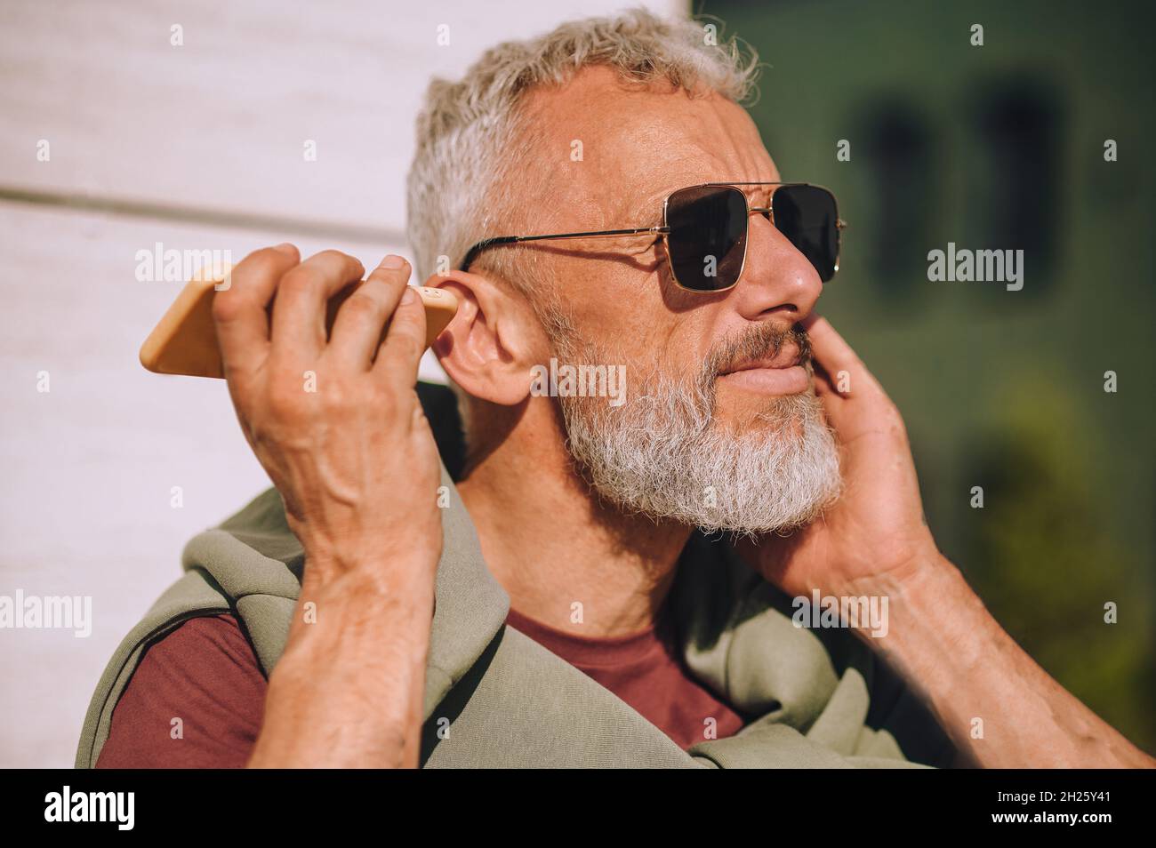 Homme jouant un message vocal sur son téléphone portable Banque D'Images