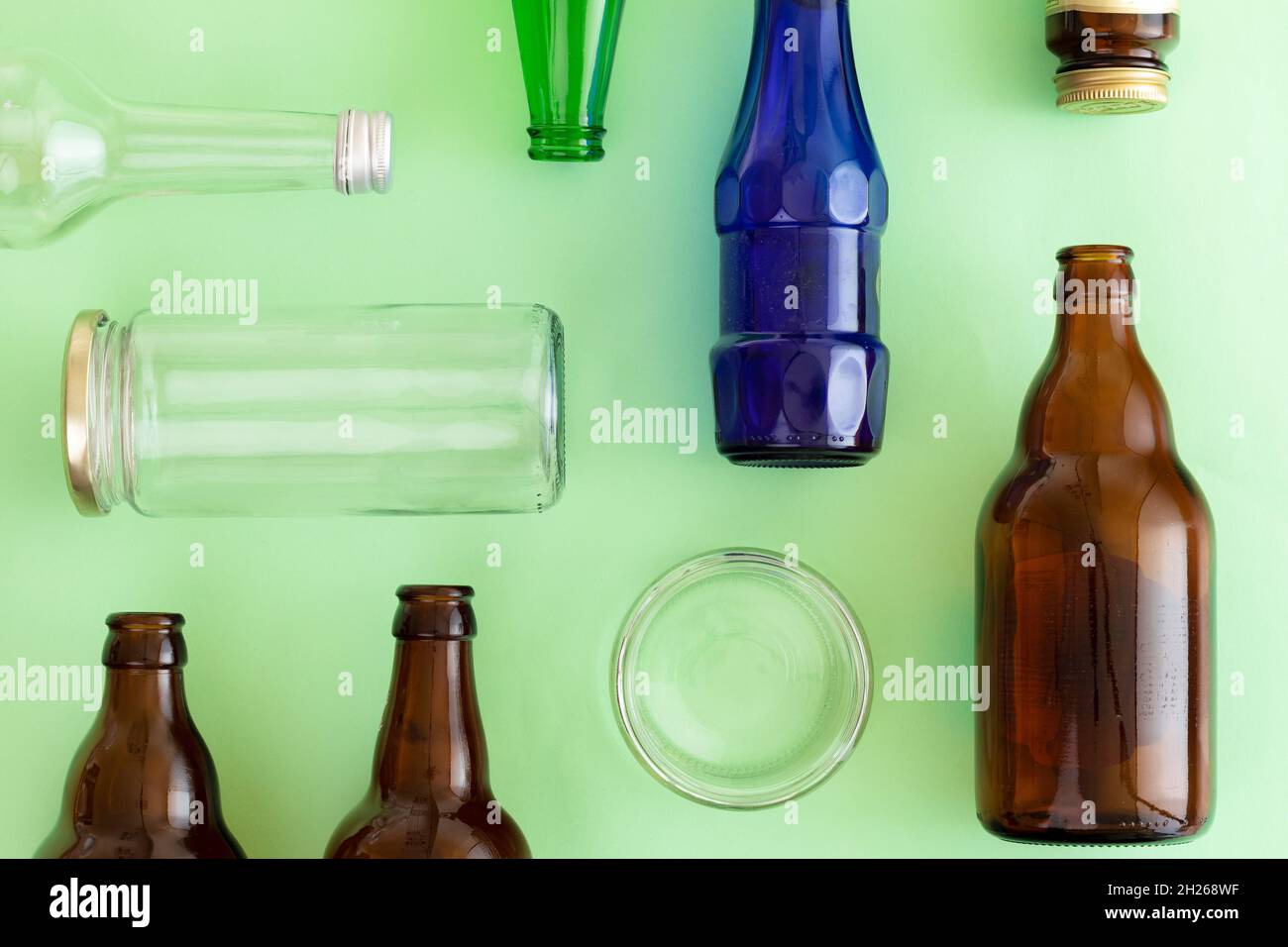 Déchets de verre posés sur fond vert isolé. Concept de gestion des déchets Banque D'Images