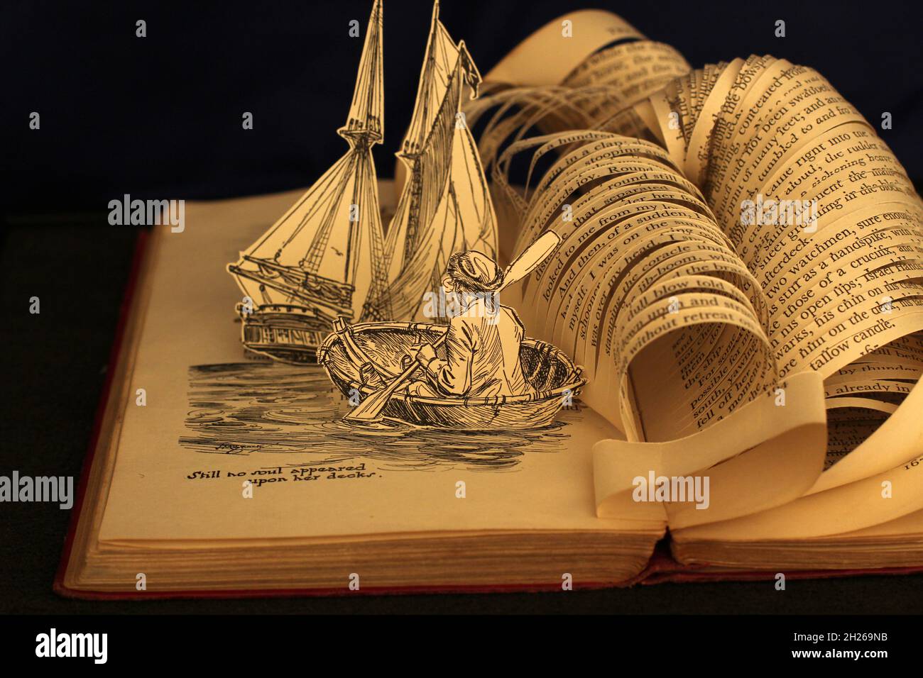 Sculpture de livre faite d'une ancienne édition illustrée de Treasure Island par Robert Louis Stevenson.Livre coupé pour faire la vague s'écraser au-dessus du navire Banque D'Images