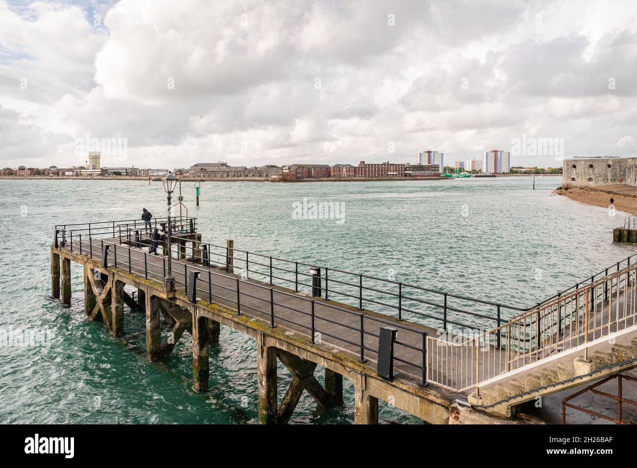 Un homme (non identifiable) qui observe des bateaux depuis Victoria Pier à l'entrée du port de Portsmouth Banque D'Images