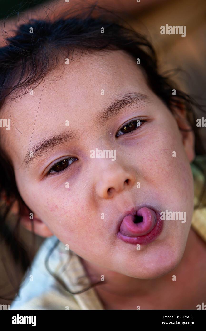 Jeune fille anglaise/thaïlandaise qui colle une langue courbé Banque D'Images