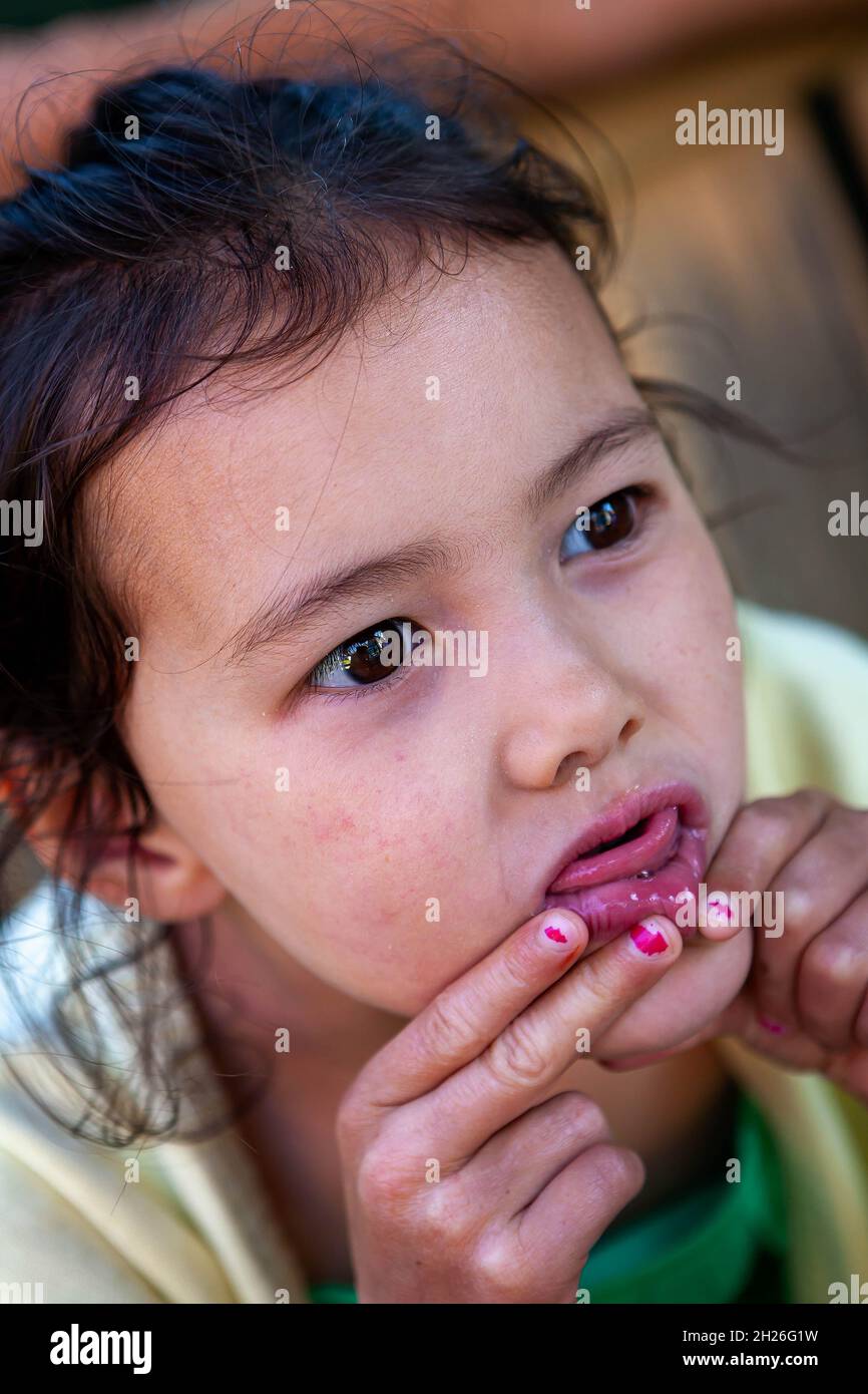 Jeune fille anglaise/thaïlandaise roulant sa lèvre inférieure pour faire un visage drôle Banque D'Images