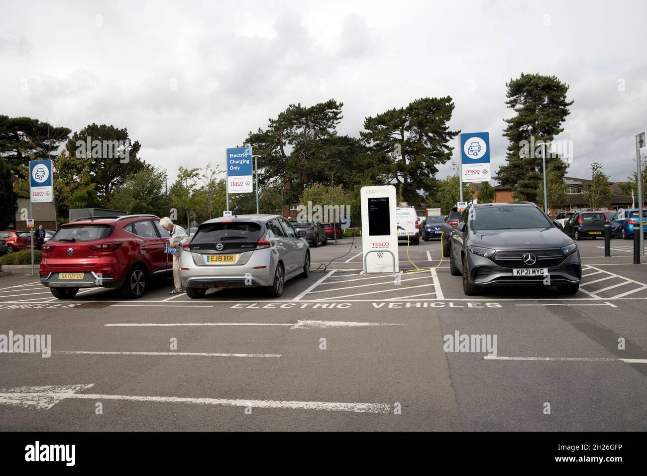 Les véhicules électriques se chargent dans une zone spéciale de charhing à VW EV chargeurs Tesco Store parking Churchdown UK Banque D'Images