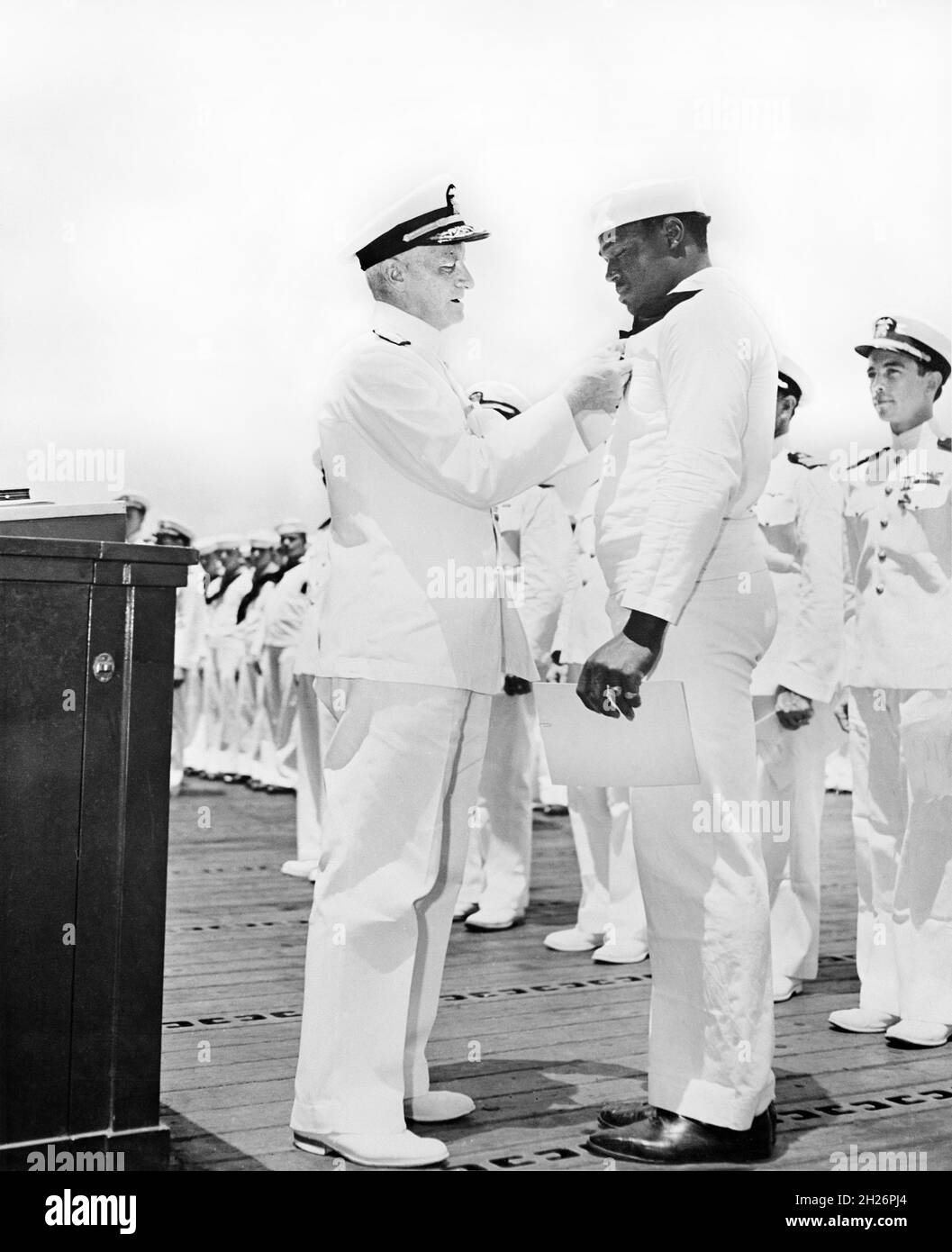 L'amiral Chester W. Nimitz pinçant la Marine Cross sur Doris 'drie' Miller lors d'une cérémonie à bord de l'USS Enterprise, Pearl Harbor, Hawaii, U.S. Office of War information, 27 mai 1942 Banque D'Images