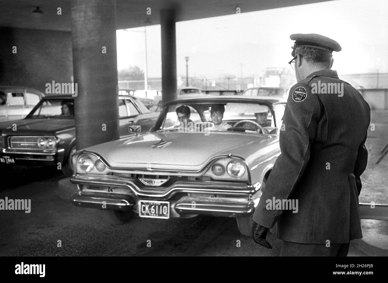 Agent de l'immigration des États-Unis regardant car car entre à El Paso, Texas, États-Unis de Juárez, Mexique, Warren K. Leffler,COLLECTION US News & World Report Magazine, 13 novembre 1964 Banque D'Images