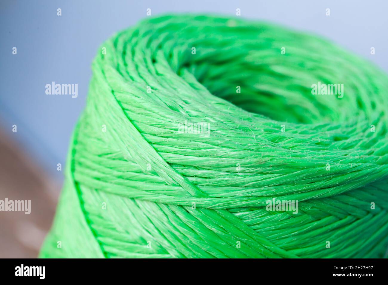 Skein de fil de polypropylène vert sur fond flou, photo de gros plan avec mise au point sélective Banque D'Images