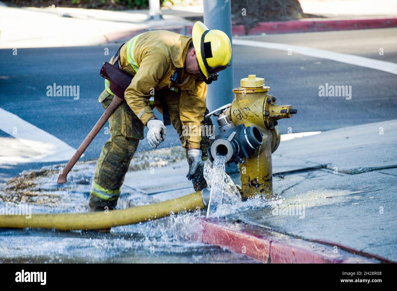 Un pompier de Los Angeles déconnecte un tuyau d'incendie d'une borne d'incendie Banque D'Images