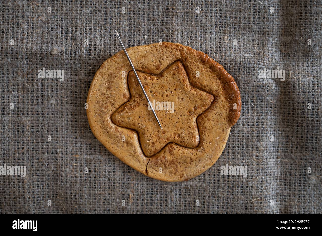Biscuits de sucre brun caramel avec une aiguille en métal en forme d'étoile.Concept de jeu de survie Banque D'Images