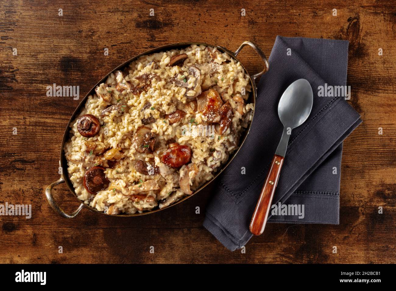 Risotto aux champignons, riz rustique aux champignons, tiré du dessus sur fond de bois sombre Banque D'Images