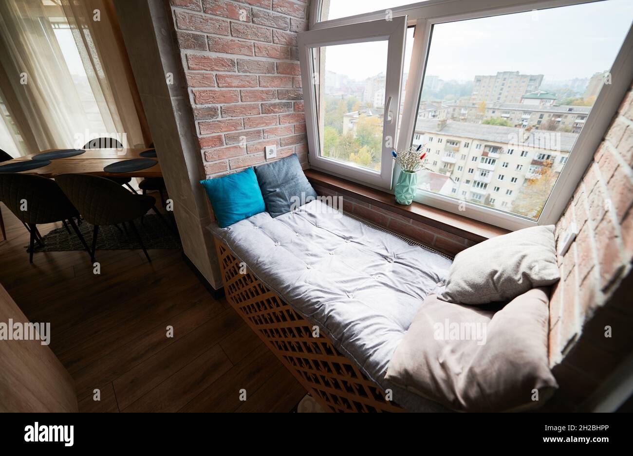 Vue sur le confortable lit avec rebord de fenêtre dans la loggia.Design de  l'appartement moderne avec place de couchage sur le seuil de la fenêtre et  parquet.Concept de style loft Photo Stock -