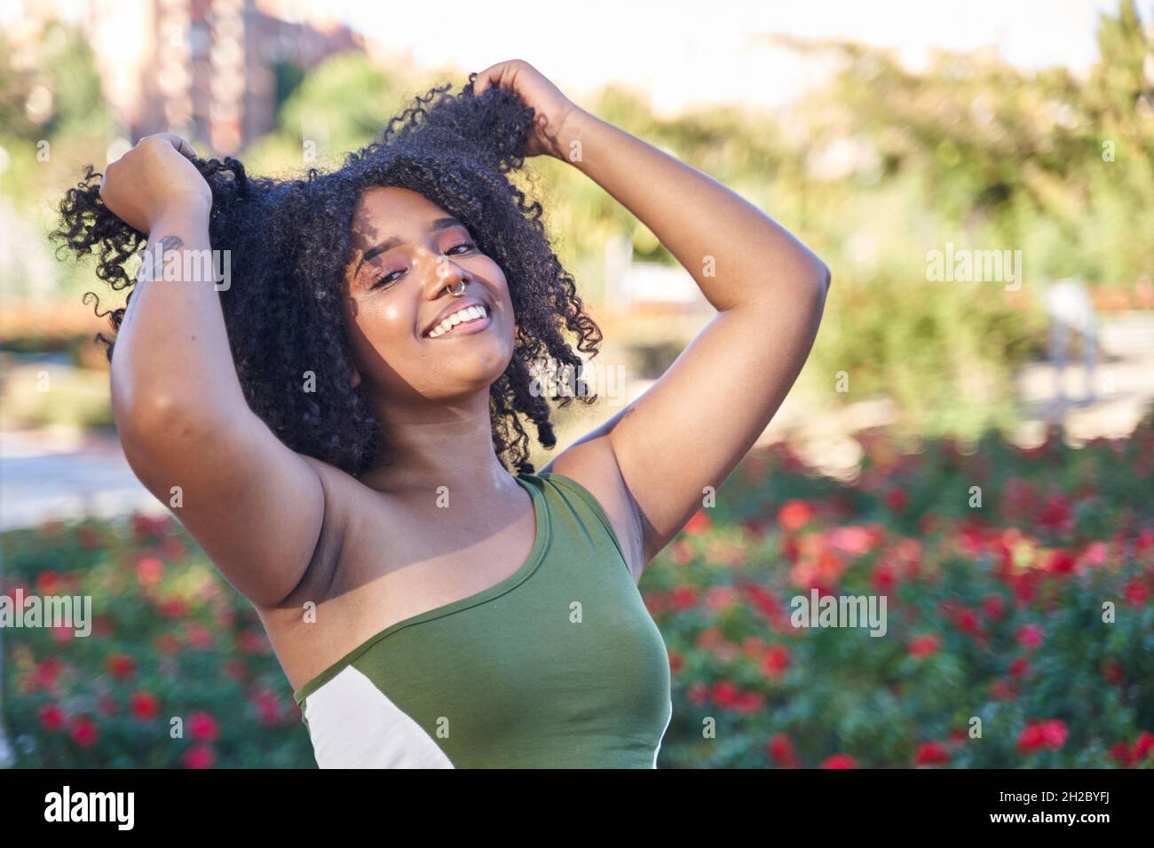 latina adolescence tirant ses cheveux bouclés avec ses mains Banque D'Images