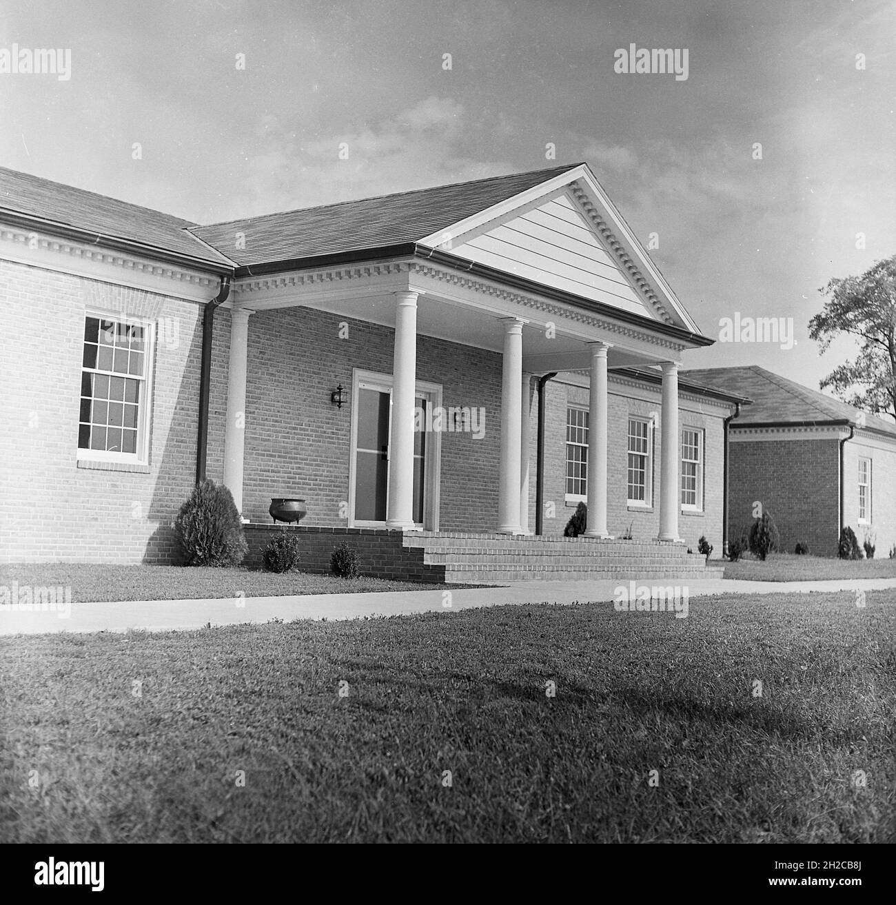 1967, vue historique et extérieure d'une entrée couverte avec colonnes d'un bâtiment d'un étage abritant un centre d'affaires à Middletown, Virginie, États-Unis. Banque D'Images