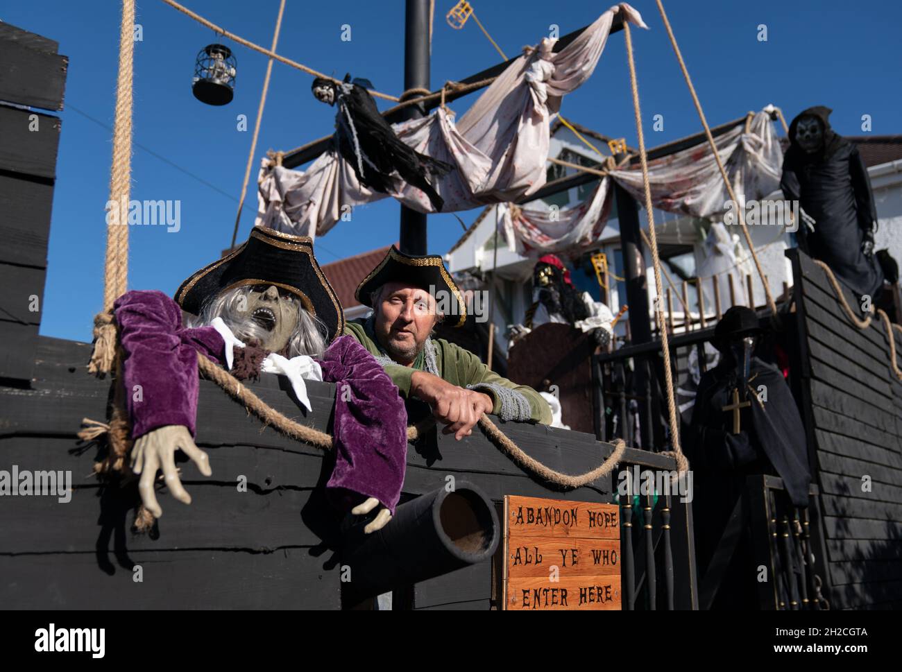 Andrew Carvel avec le bateau pirate géant « Elizabeth Dane » qu'il a construit en utilisant du bois de ferraille dans le jardin de sa maison à Tamworth, Staffordshire.Le navire mesure neuf mètres de long et est orné d'un drapeau pirate, de squelettes et de voiles sanglées, et il a fallu quelques semaines à M. Carvel pour le construire.Date de la photo: Jeudi 21 octobre 2021. Banque D'Images