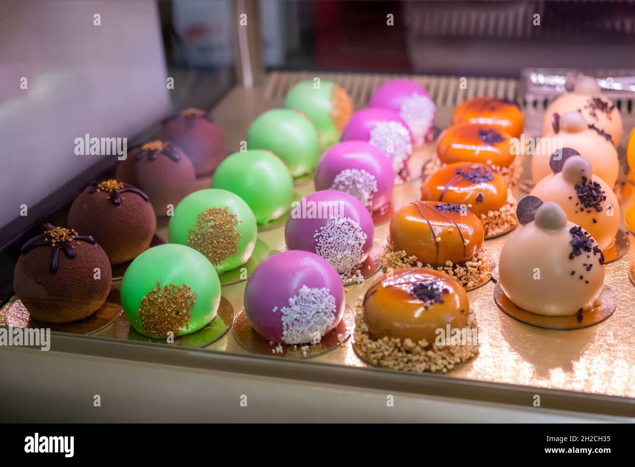 Ensemble de gâteaux de mousse multicolores avec glaçage miroir brillant sur  le comptoir du marché alimentaire Photo Stock - Alamy