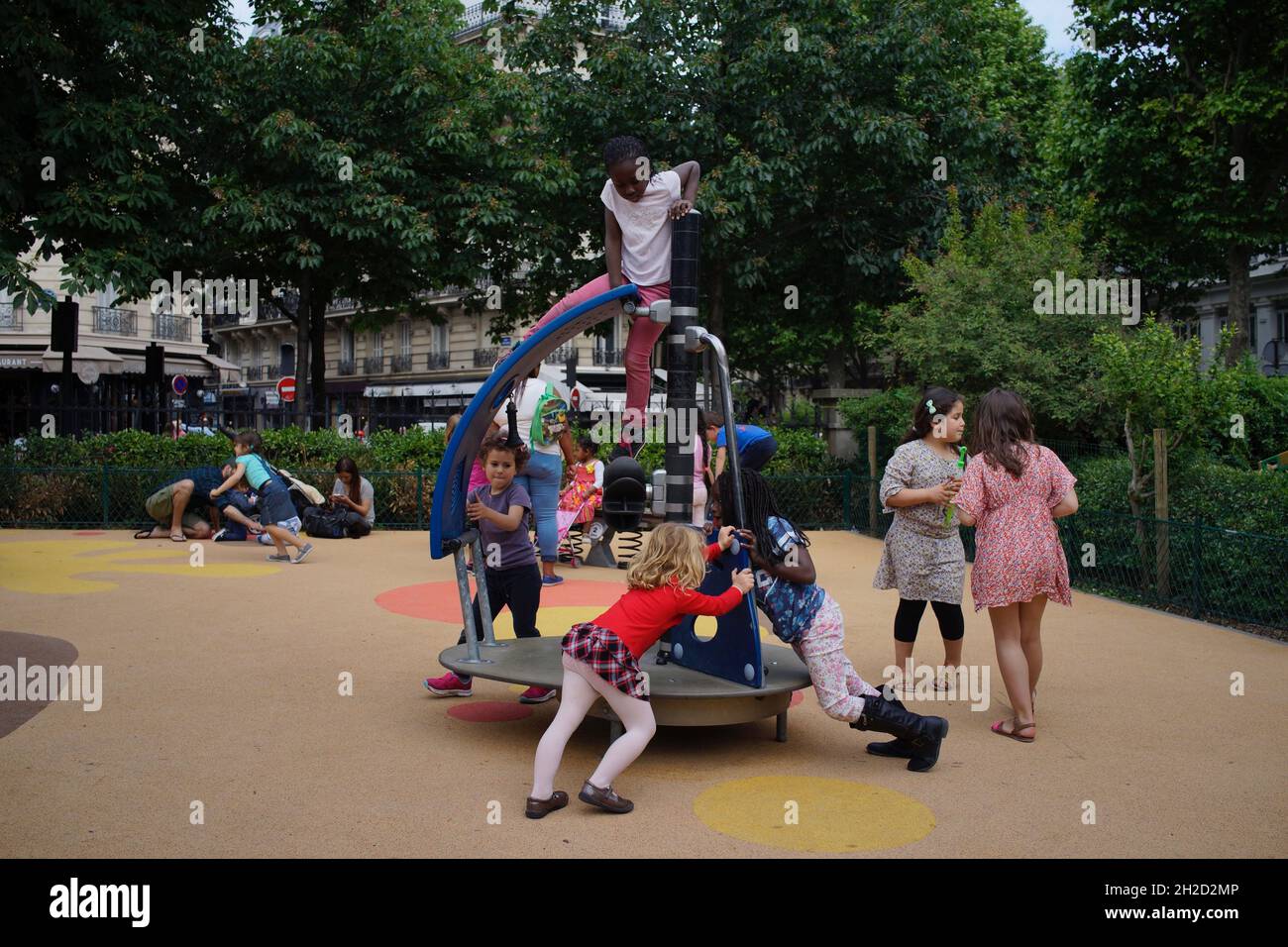 Des enfants de divers âges et origines ethniques jouent ensemble dans le terrain de jeu de la place d'Anvers, 75009 Paris, France Banque D'Images