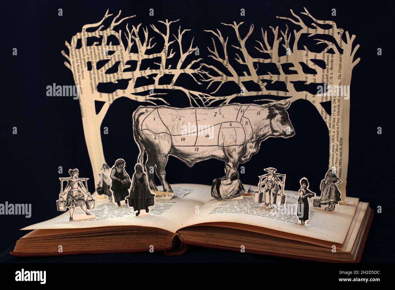 Sculpture sur papier de huit femmes de ménage une traite, illustration d'une vache géante entourée de femmes de race. Banque D'Images