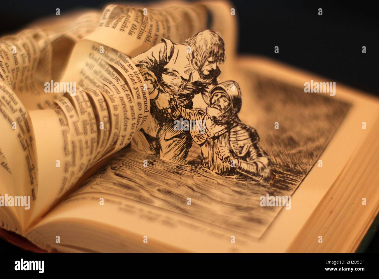 Sculpture de livre faite des progrès du pèlerin par John Bunyan plein d'espoir sauvant son frère de la noyade papier art. Woth flou bokeh arrière-plan. Banque D'Images