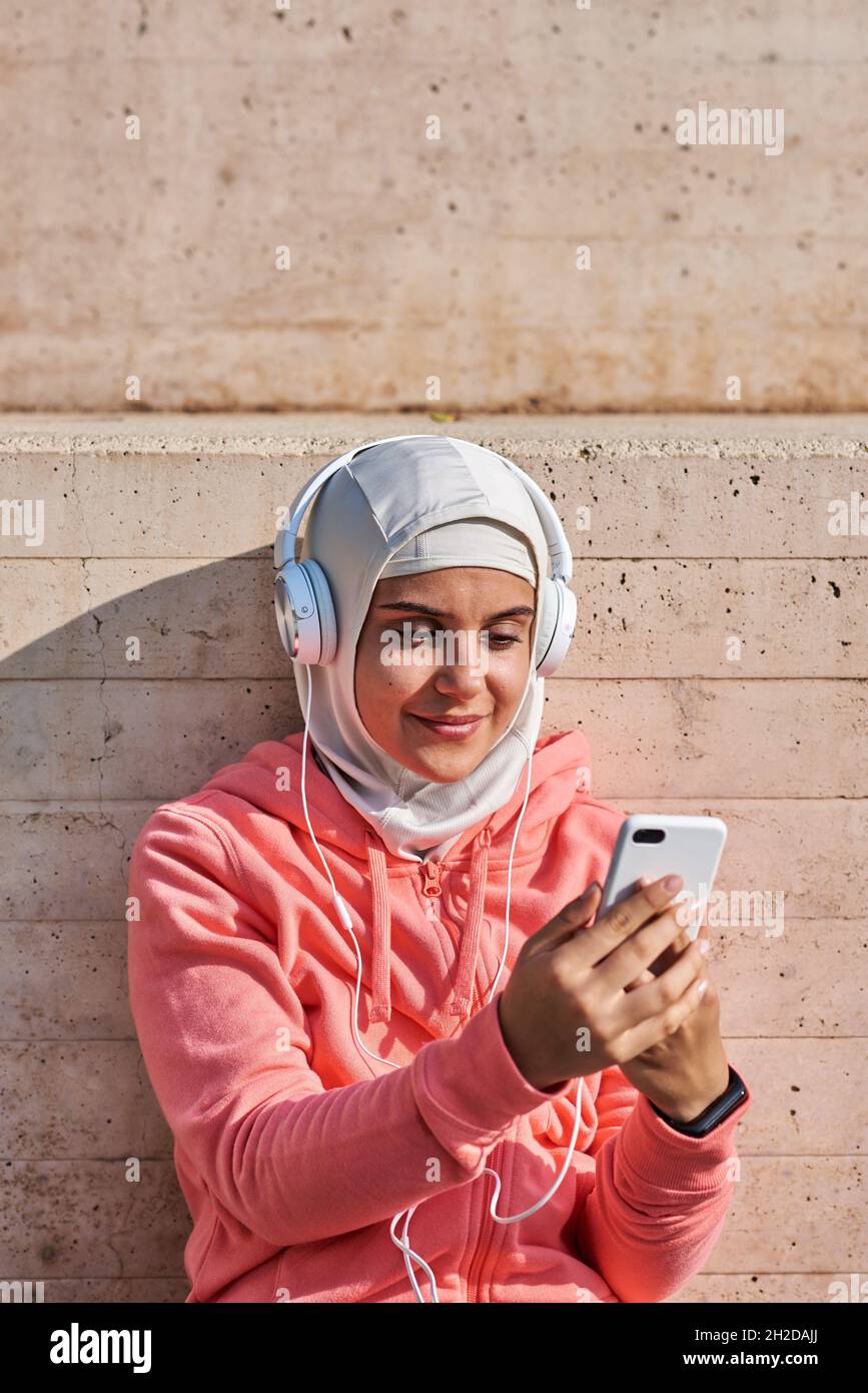 Jeune femme musulmane avec casque faisant une pause Banque D'Images