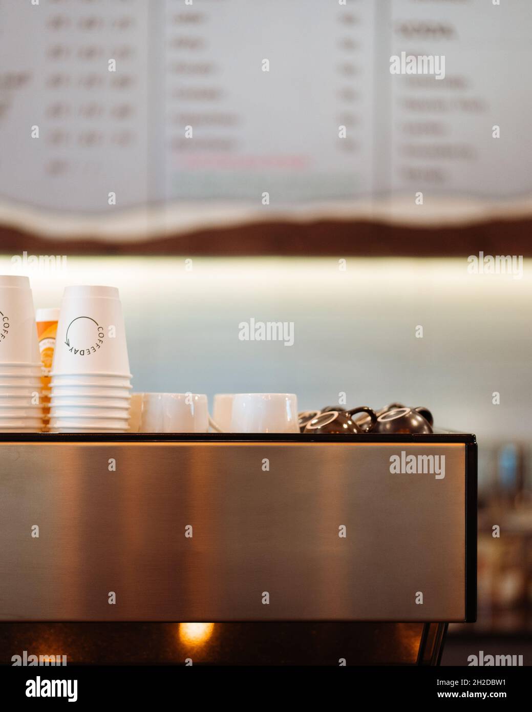 Une machine à café dans un café se tient sur une table avec des tasses à café Banque D'Images Une machine à café dans un café se tient sur une table avec des tasses à café Banque D'Images