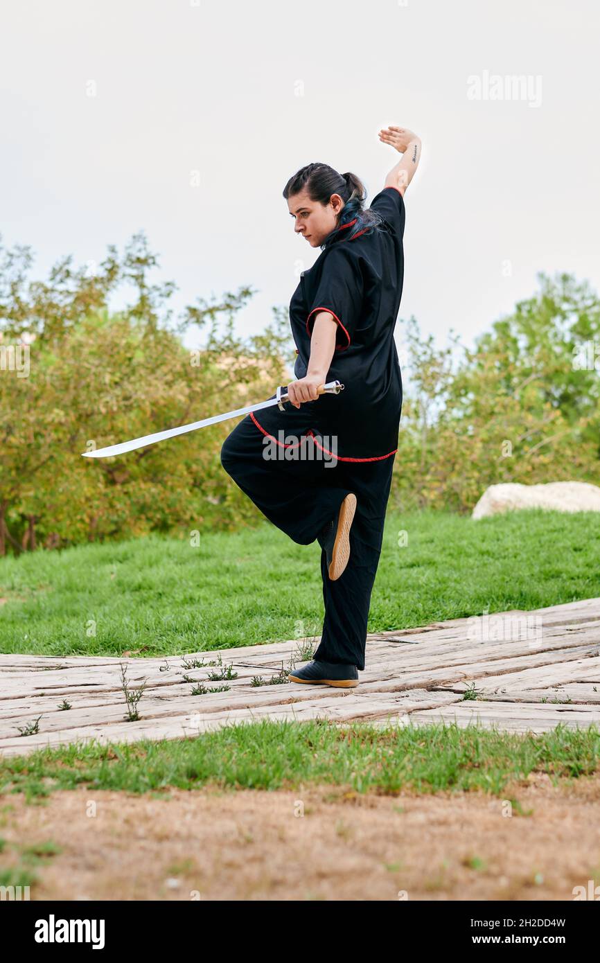 Une femme pratique le kung fu avec une épée Banque D'Images