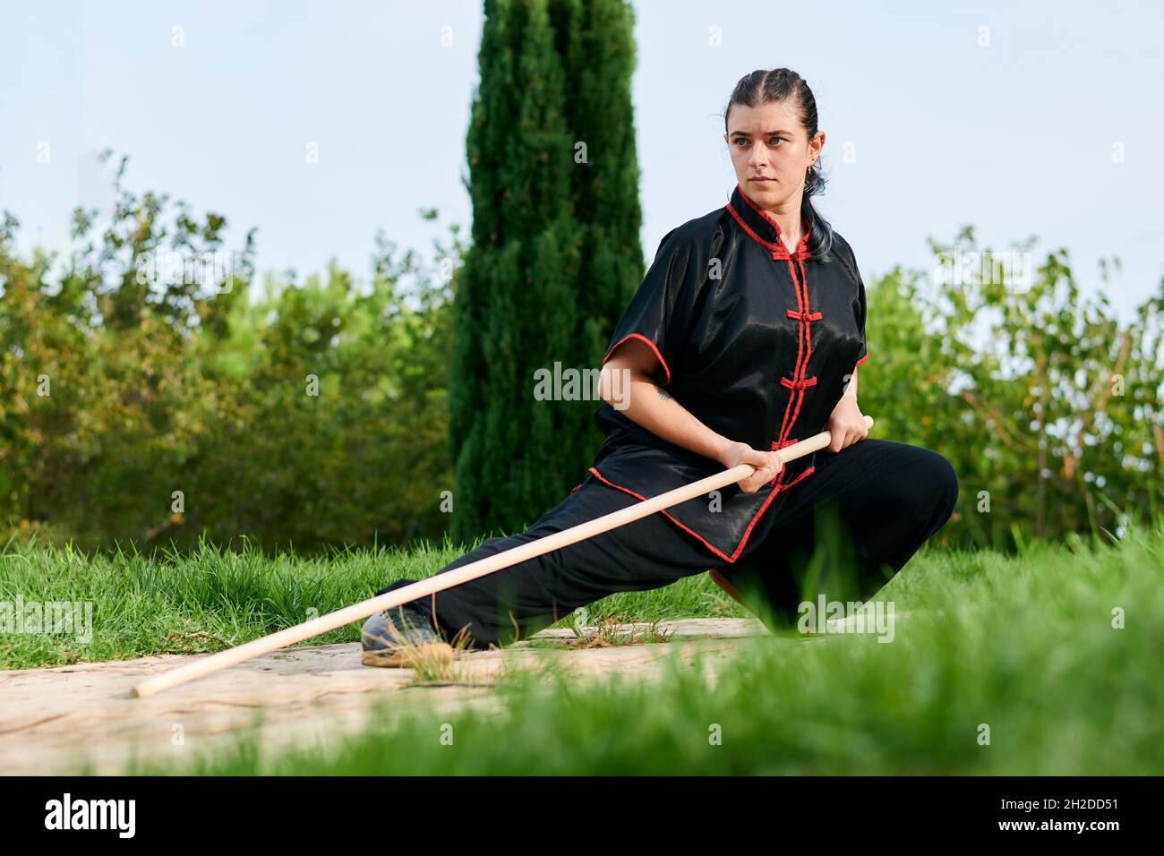 Une femme pratique le kung fu avec un bâton Banque D'Images