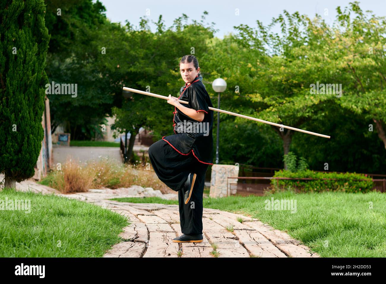 Une femme pratique le kung fu avec un bâton Banque D'Images