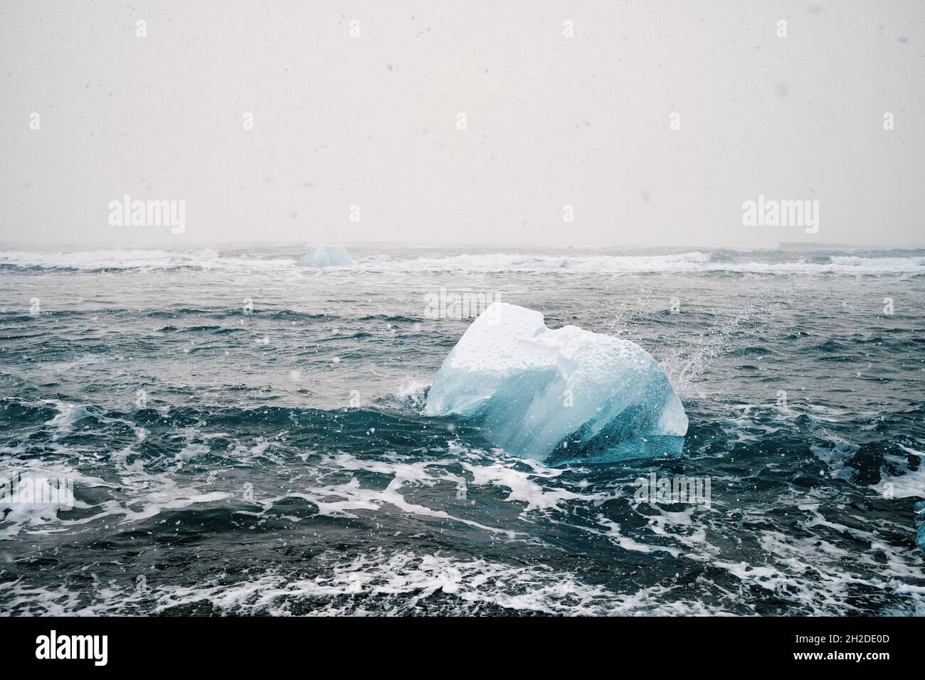 Vue pittoresque de glace dans un océan ondulé avec des liquides d'eau mousseuse sous un ciel clair en Islande Banque D'Images