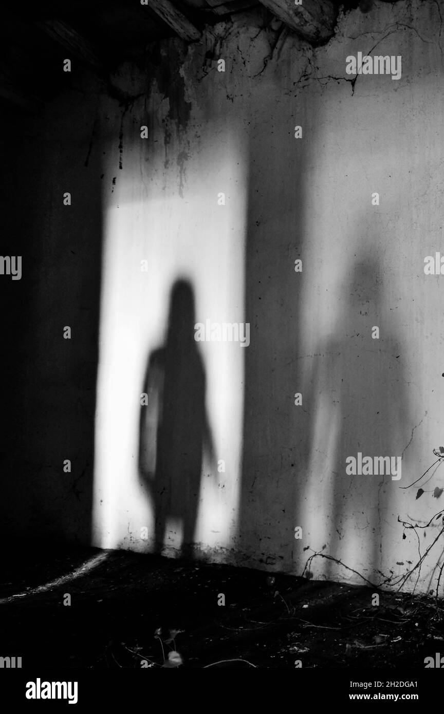 Ombre mystérieuse et effrayante d'une femme dans une maison abandonnée - Silhouette de fantôme femelle debout sur la porte de la pièce - concept de peur dans aba Banque D'Images