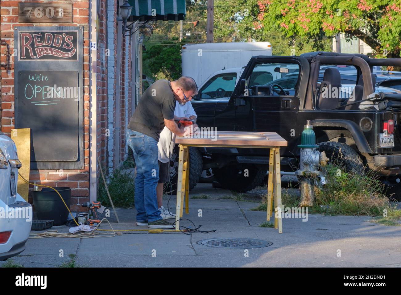 LA NOUVELLE-ORLÉANS, LA, États-Unis - 19 OCTOBRE 2021 : les charpentiers sablant le panneau de porte devant la taverne Uptilly de REDD sur Maple Street Banque D'Images